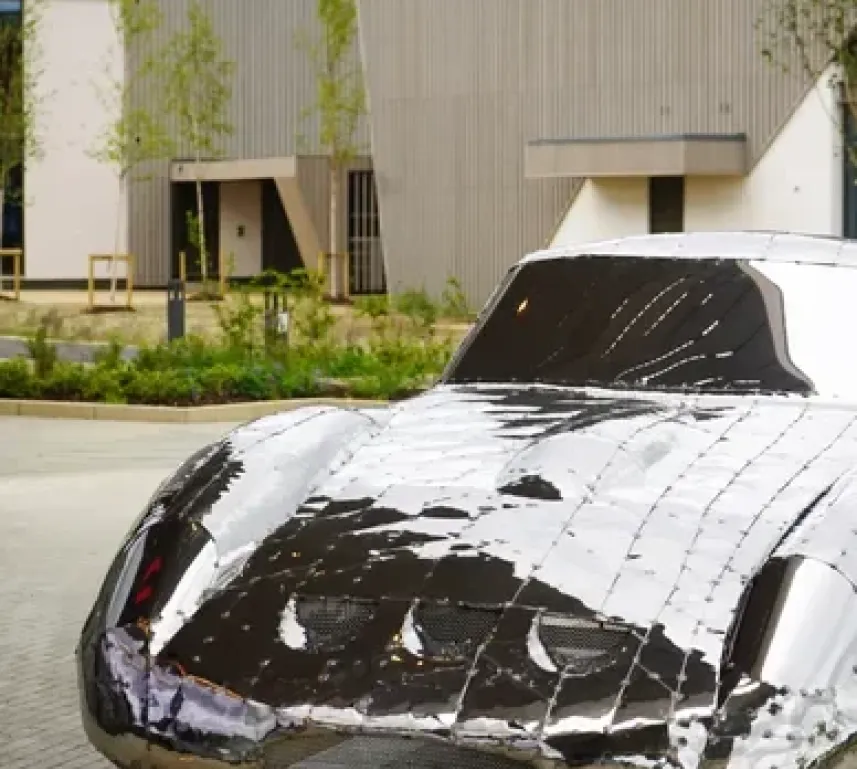 Image of a silver car sculpture in the shape of a classic sports car